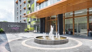 Un bâtiment moderne, sur lequel on peut lire l’inscription « Calypso Garden », et qui est agrémenté d’une fontaine centrale.