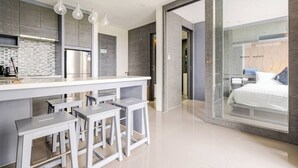 Una cocina moderna con una isla central, taburetes de bar e iluminación colgante.