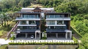 A modern, multi-story residential building with a symmetrical design, large windows, and a flat roof. - La vista Villas by Villacarte (Chalong)