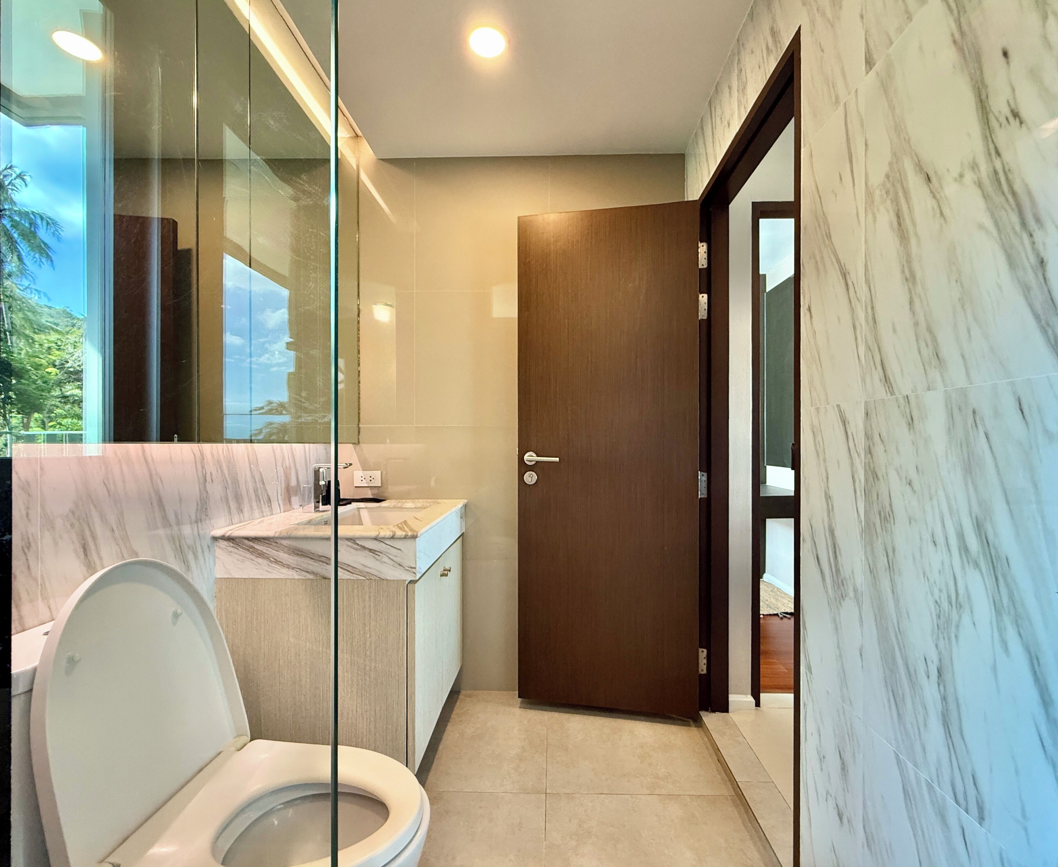 Un baño moderno con inodoro, lavabo y zona de ducha.