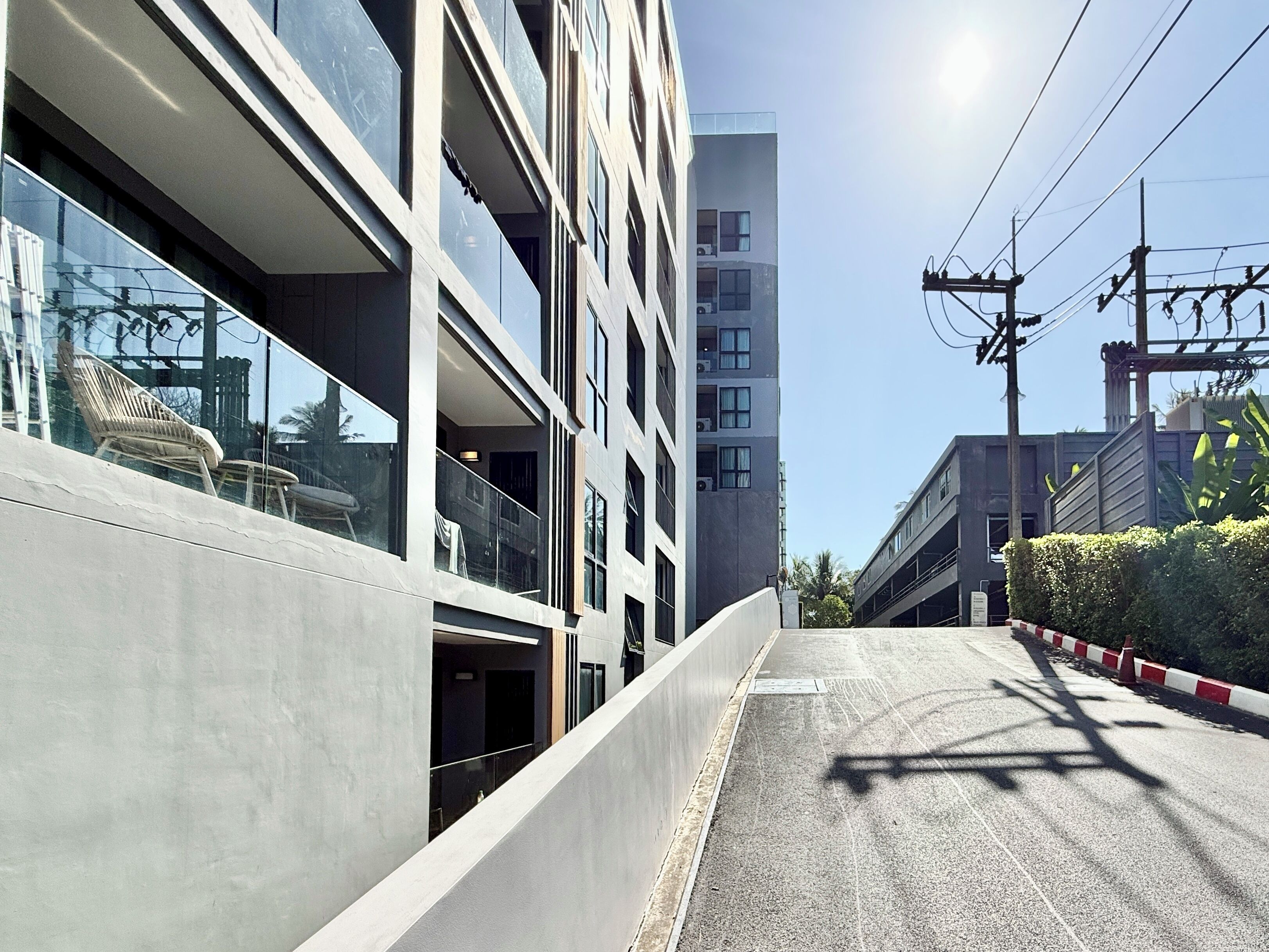 Un bâtiment moderne doté de grandes fenêtres, d’un balcon et offrant une vue sur un ciel dégagé.