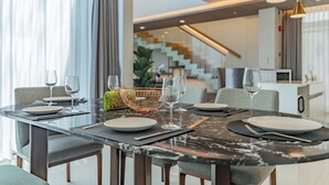 A dining area with a modern table set for four, including plates, glasses, and cutlery. - Panora Villa 8119 By Villacarte (Choeng Thale)