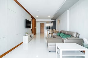 A modern living room with a sofa, a coffee table, and a TV.
