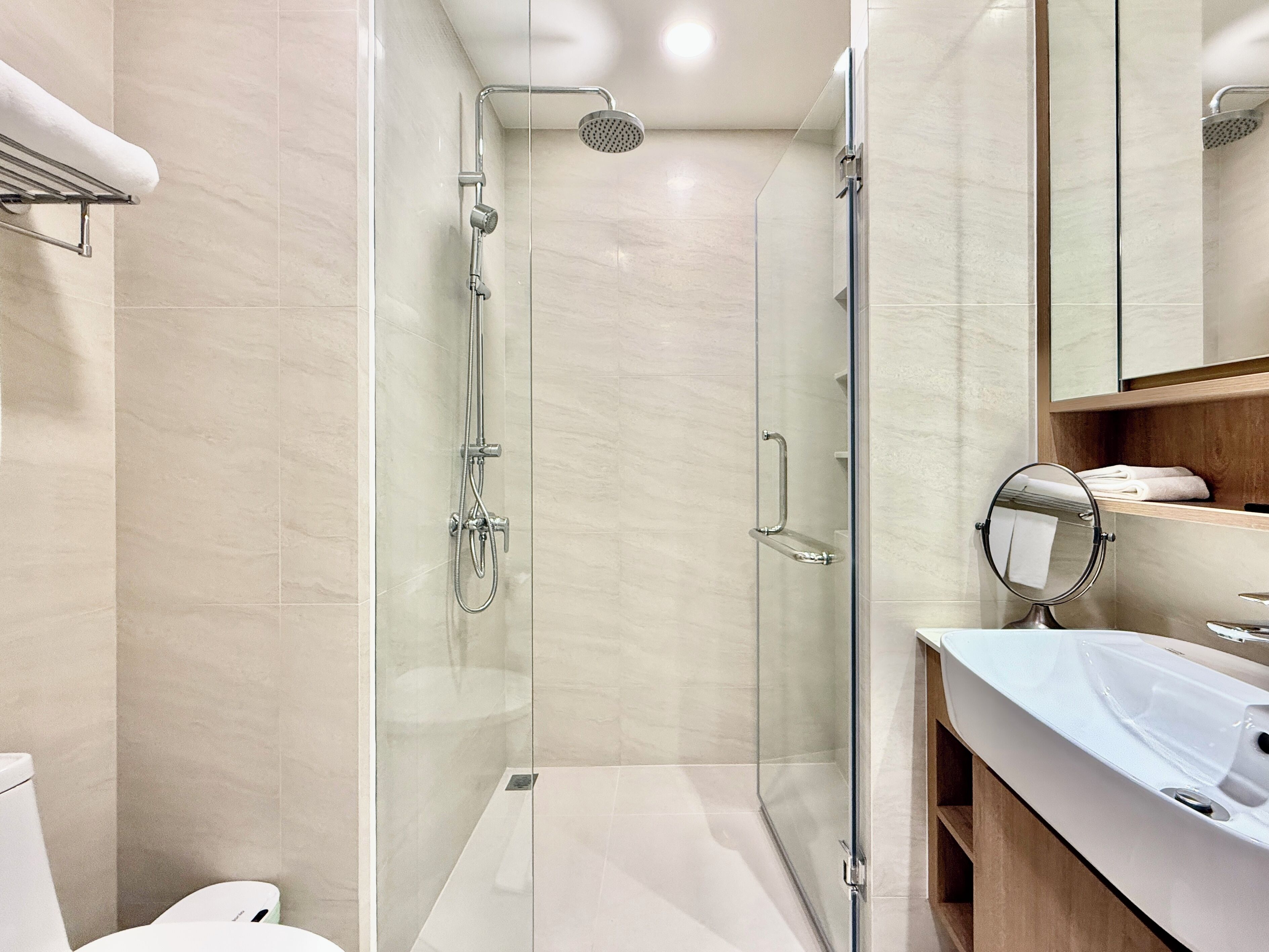 Une salle de bain moderne avec une douche à parois de verre, un meuble-lavabo avec un miroir et des toilettes.