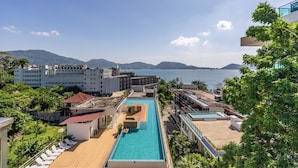 Un complexe hôtelier doté d’une grande piscine, de plusieurs bâtiments et offrant une vue sur la mer.