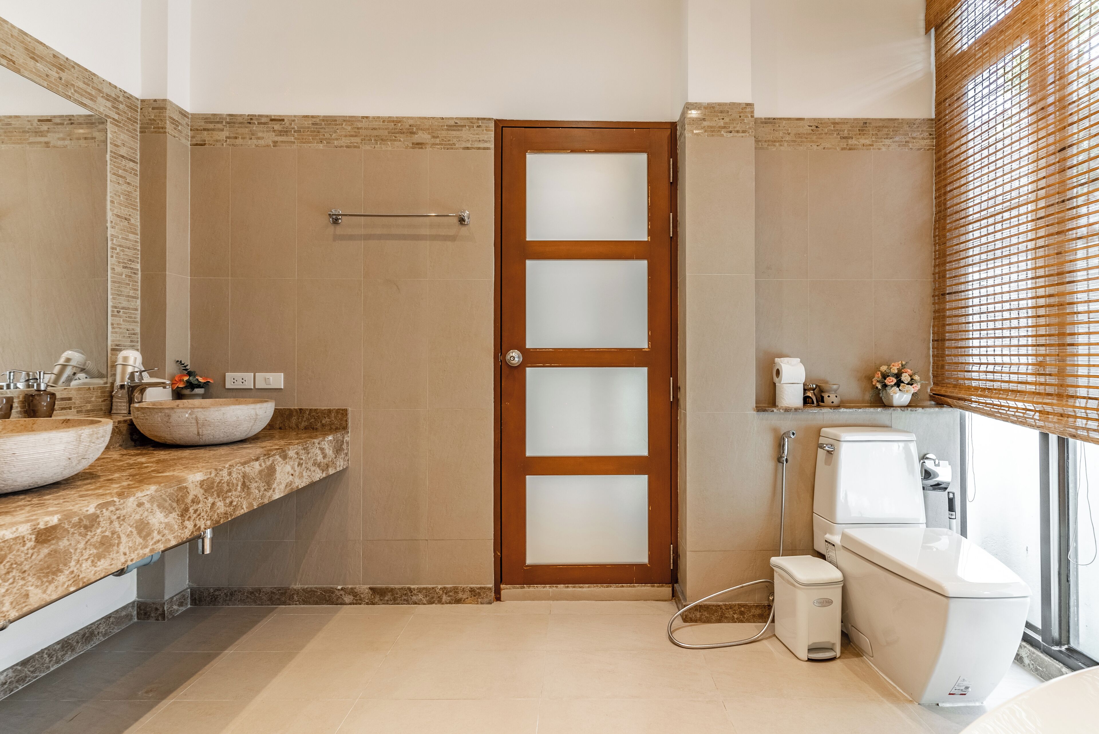A modern bathroom with two sinks, a toilet, and a shower.