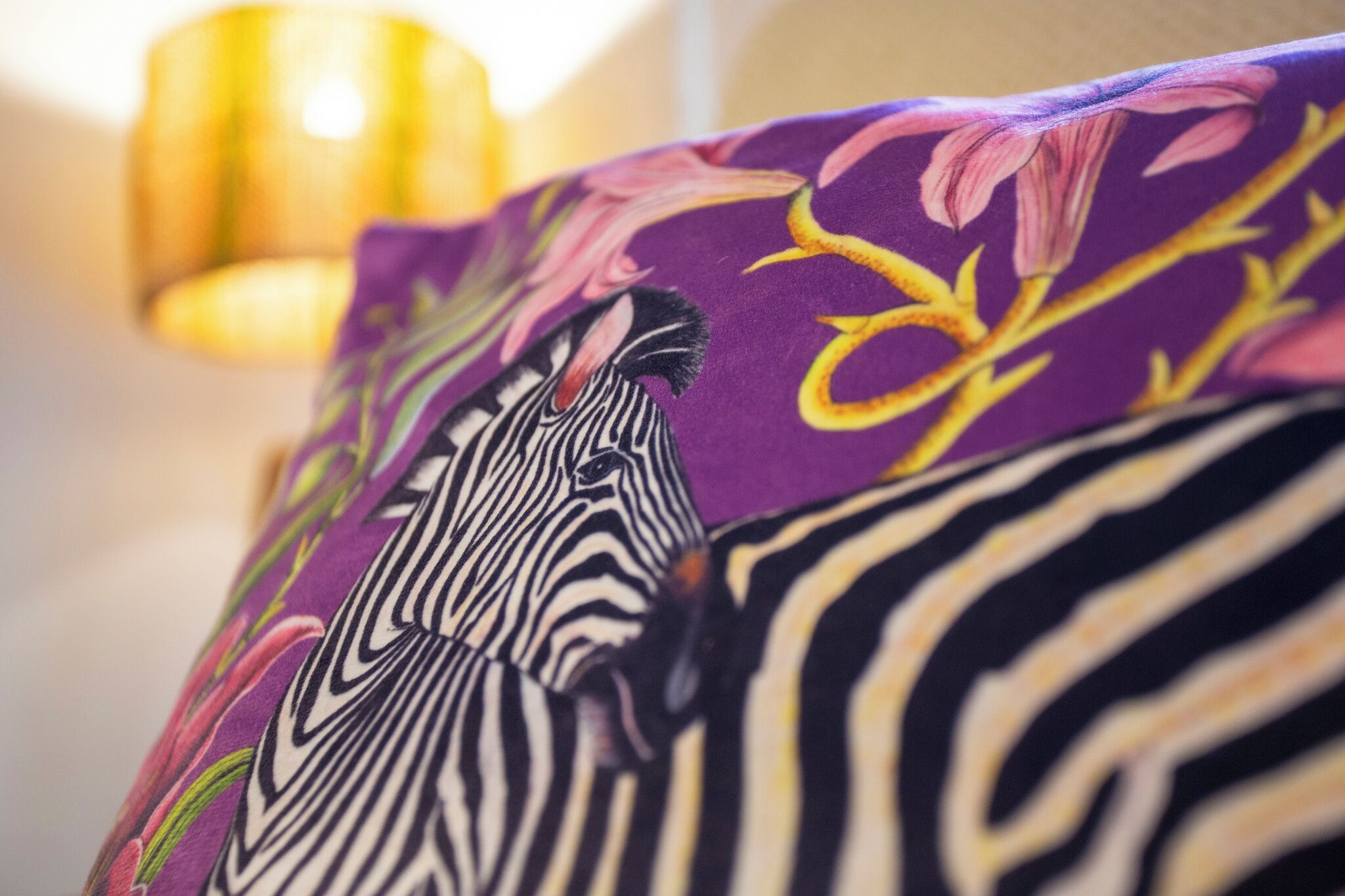 A close-up of a purple fabric with a zebra and floral pattern.