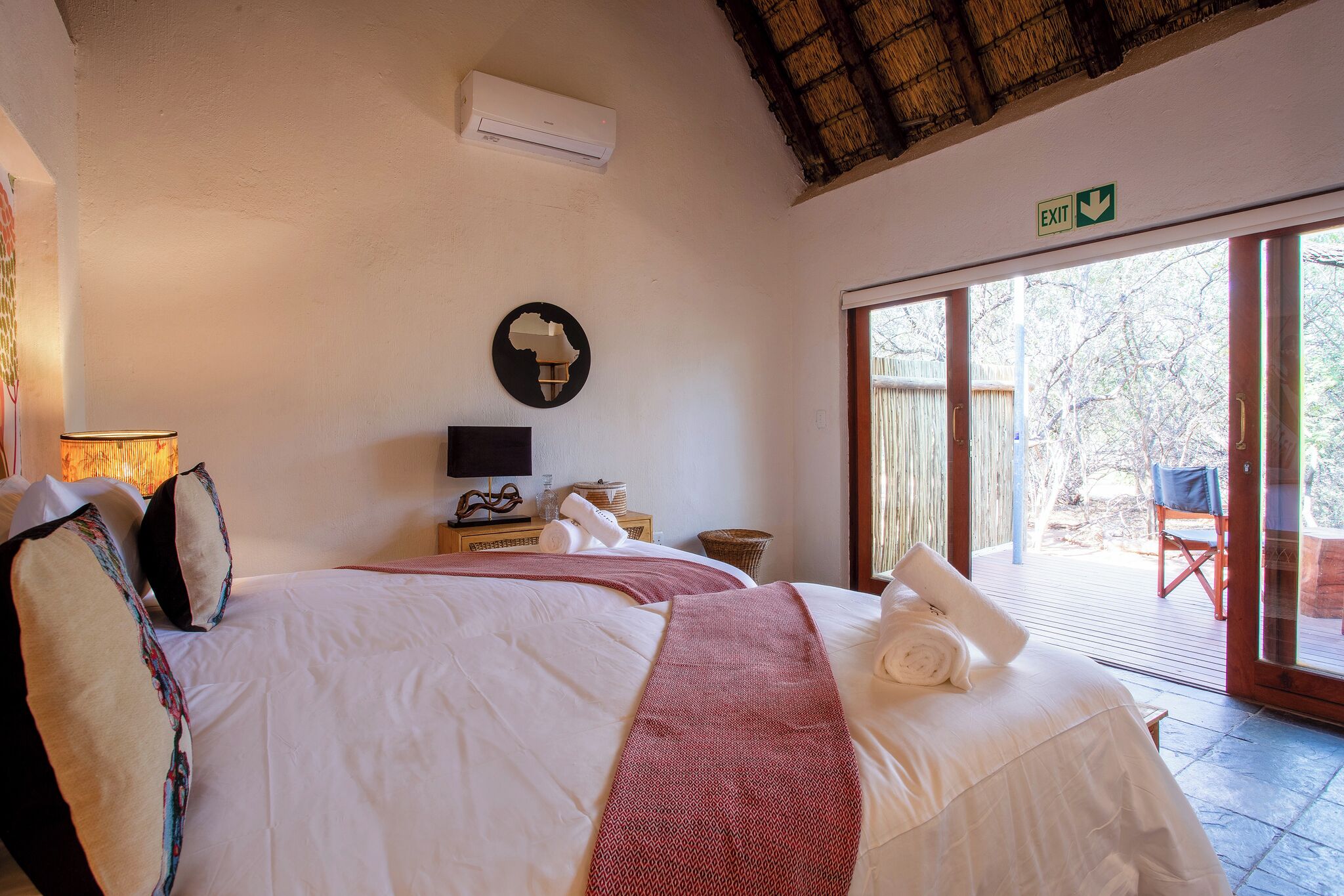 Ein Hotelzimmer mit Bett, Fernseher, Wand-Klimaanlage und Blick ins Freie.