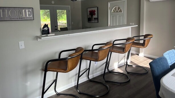 A kitchen area with a bar counter and four bar stools. - Relaxing 3-Bedroom Getaway in Peaceful Cades – Sleeps 8 (Cades)