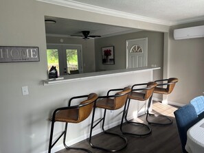 A kitchen area with a bar counter and four bar stools.