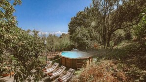 Una vasca idromassaggio circondata da poltrone relax in un giardino.