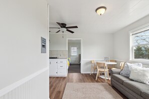 Une cuisine moderne avec des armoires blanches, un ventilateur de plafond et une fenêtre.