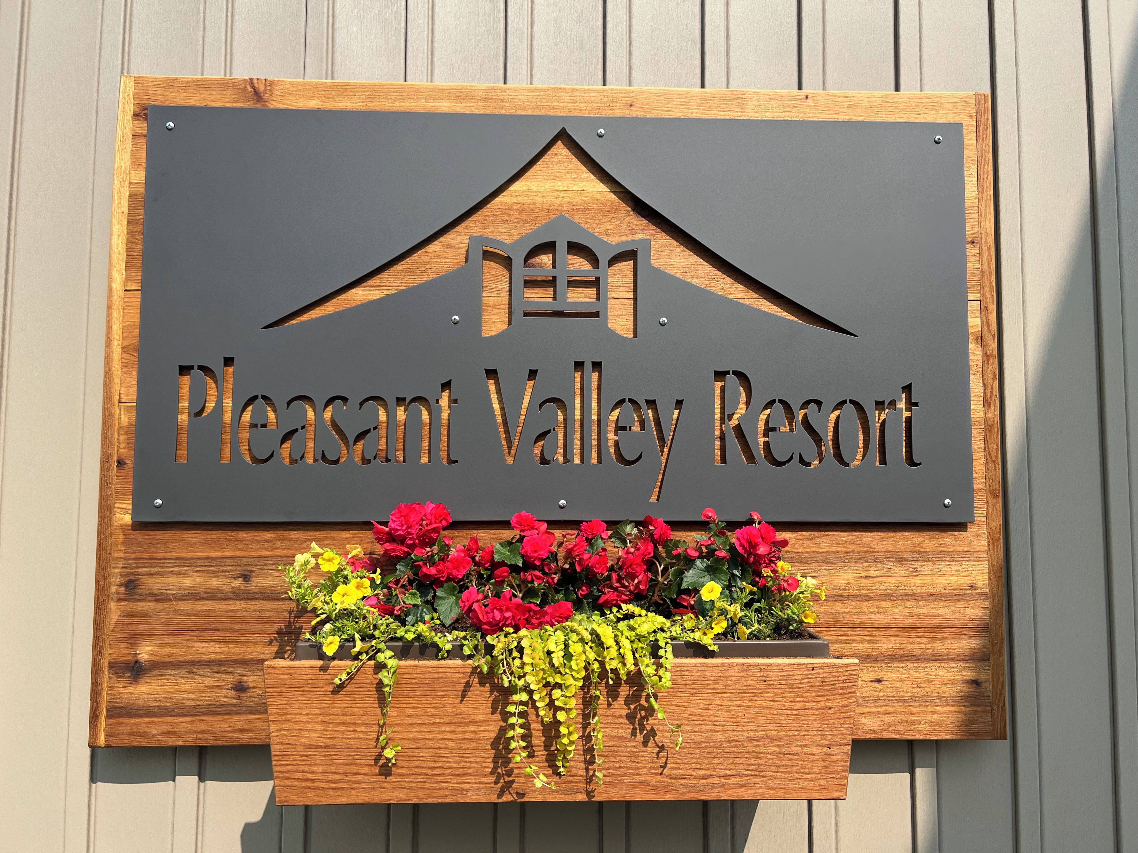 A sign for Pleasant Valley Resort with a house symbol and text.