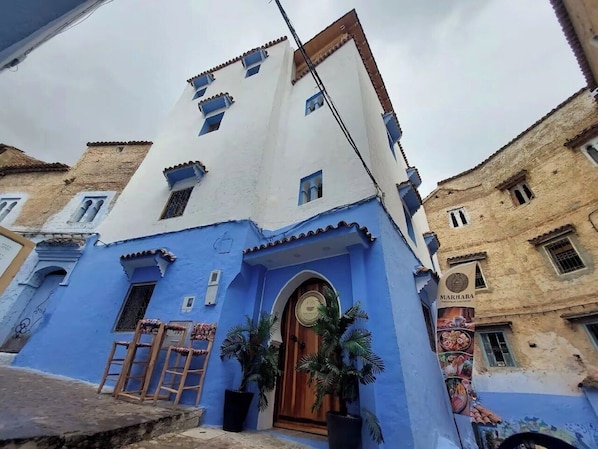 A building with a blue facade, a wooden door, and a sign that reads "MARHABA". - Diyar Marhaba (Chefchaouen)