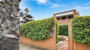 Une maison moderne avec une clôture en bois et un jardin bien entretenu.