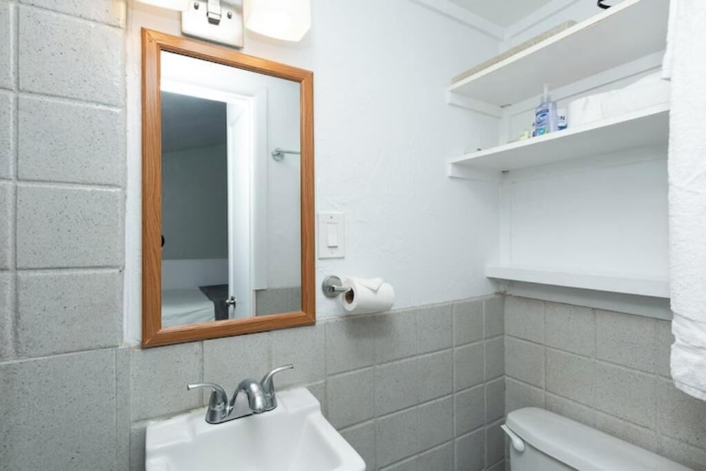 Ein Badezimmer mit Waschbecken, Spiegel und Toilette.