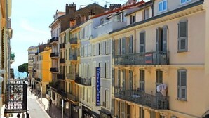 A row of multi-story buildings with balconies, a visible hotel sign, and a pedestrian street. - Lovely and Modern 1 Bedroom City Centre Cannes (Cannes)