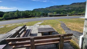 A paved area with wooden benches and a stone wall. - Lingmell Fell View, Chapel Stile (Chapel Stile)