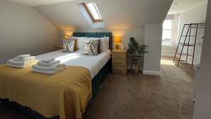 A bedroom with a bed, bedside tables, a lamp, a potted plant, and a skylight. - Forth, seaside 3 bed apartment, stunning views, convenient, central location , (Pittenweem)