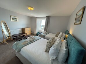 A hotel room with two beds, a dresser, a vanity mirror, a desk, and a window with curtains. - Forth, seaside 3 bed apartment, stunning views, convenient, central location , (Pittenweem)
