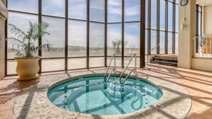 An indoor swimming pool with a view of the city through large windows.