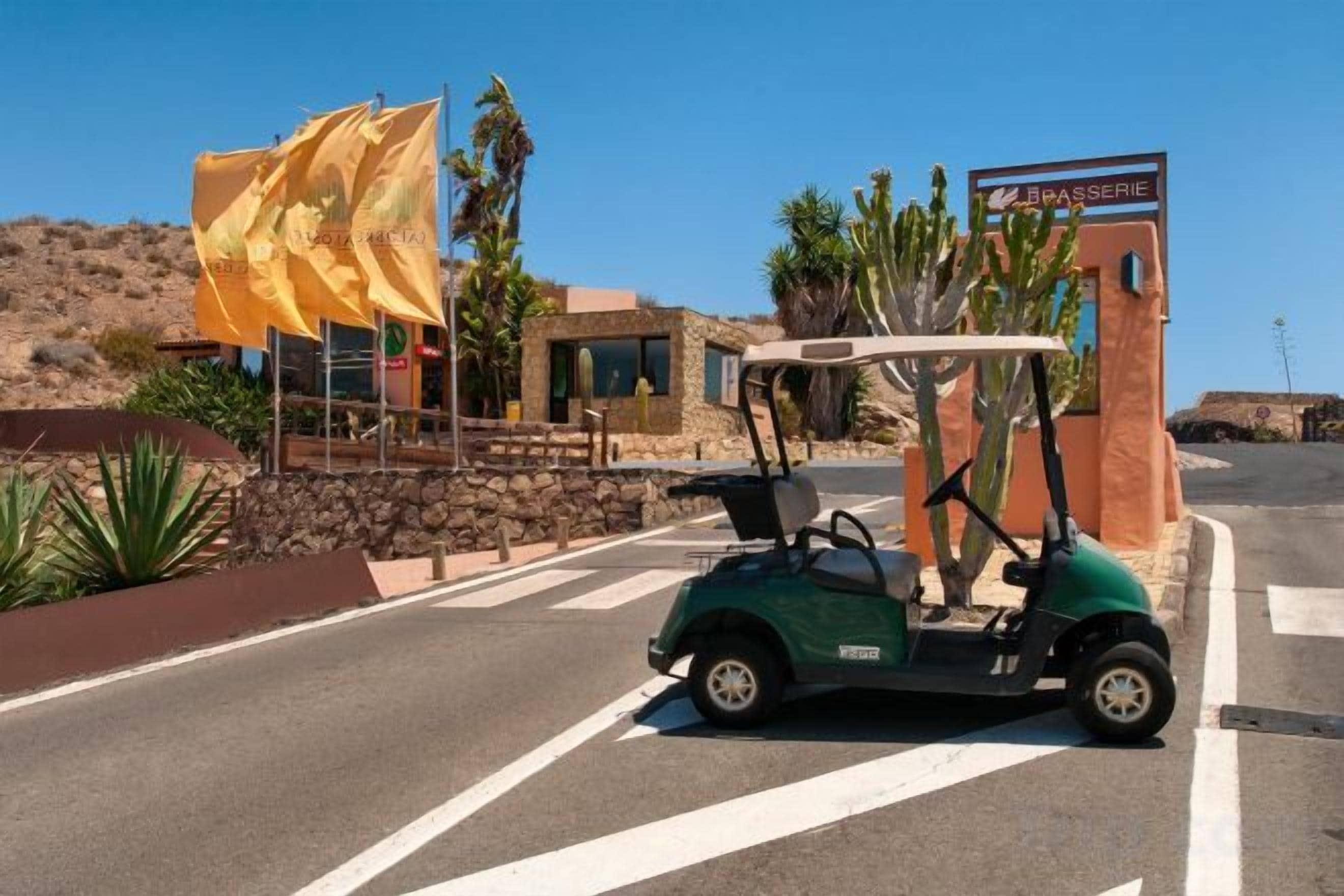 A golf cart parked in a parking lot with a building in the background.