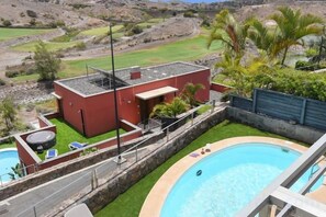 Et moderne hus med swimmingpool, tennisbane og udsigt over det omkringliggende landskab.