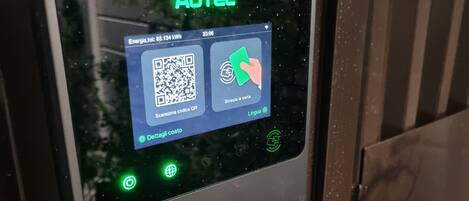 Pantalla digital con un código QR y un icono de mano, indicando una función de pago o escaneo.