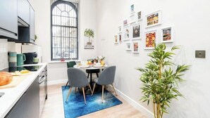 A modern kitchen with a dining area, a large window, and wall art. - Stunning Apartment in Leeds (Leeds)