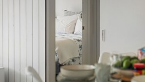Une chambre à coucher avec un lit, des oreillers et un tableau accroché au mur.