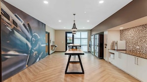 A modern kitchen with a wooden floor, a central island, and a large window.
