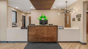 A reception area with a wooden reception desk, a Lenovo logo, and a modern chandelier.