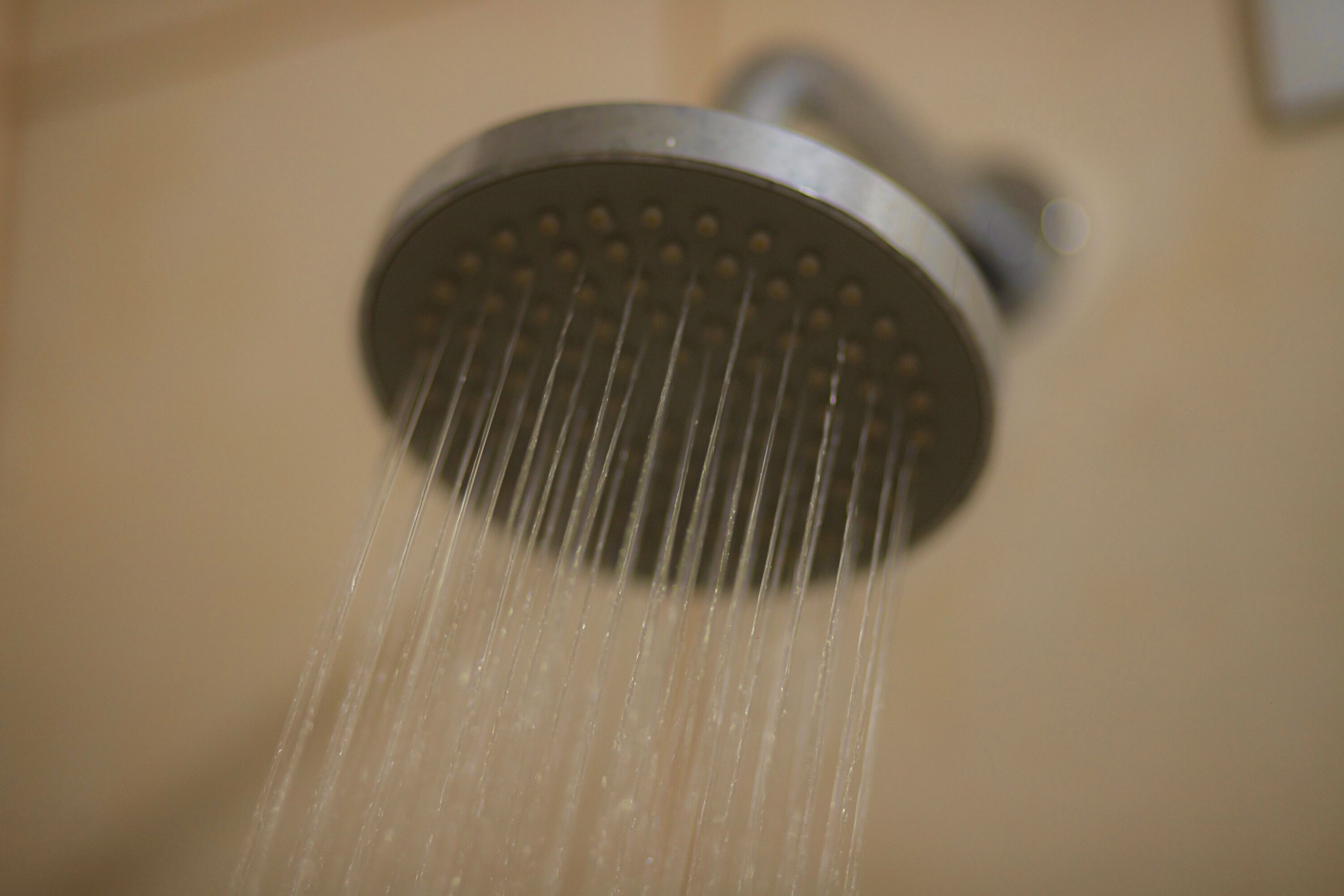 Un cabezal de ducha con agua corriendo.