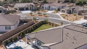 A residential area with houses, a swimming pool, and mountains in the background. - The Palms Hideaway - Desert Luxury (La Quinta)
