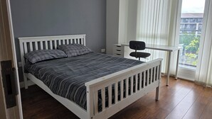 A bedroom with a bed, a desk, and a chair. - Exceptional Two-Bedroom Apartment in the City Center. (Birmingham)