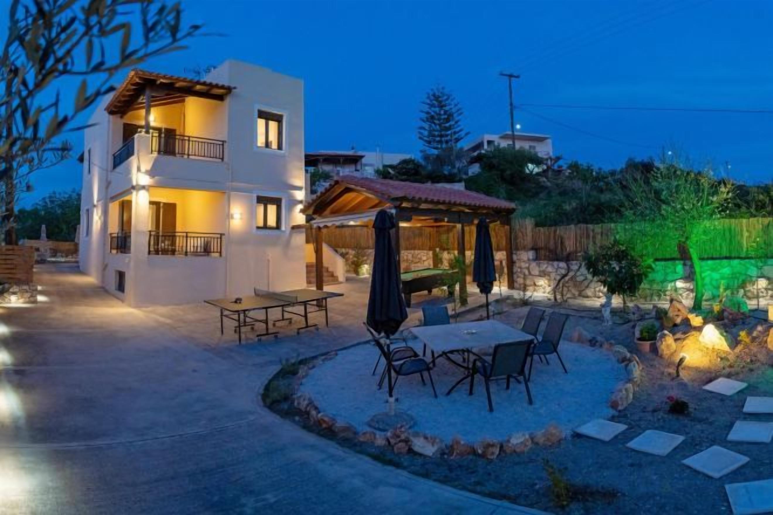 A two-story building with a patio area featuring outdoor furniture and a covered seating area.