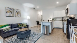 A modern apartment with a living area, kitchen, and dining space.