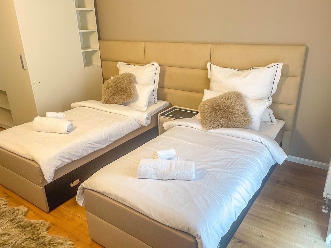 Une chambre d’hôtel avec deux lits, chacun doté d’une tête de lit, de draps blancs et d’un oreiller moelleux.