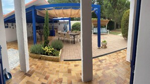 A covered patio area with a tiled floor, outdoor furniture, and a garden bed with plants. - HOUSE SLEEPS 8 SEASIDE - PRIVATE POOL - ENCLOSED PARK - PRIVATE PARKING (Saint-Cyprien)