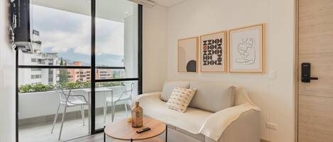 Relax in this stylish living room with a sofa, coffee table, and balcony access.