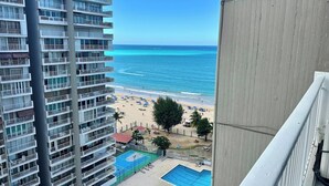 A high-rise building with multiple balconies overlooking a beach and a pool area. - Apartment with Sea View in Isla Verde (Carolina)