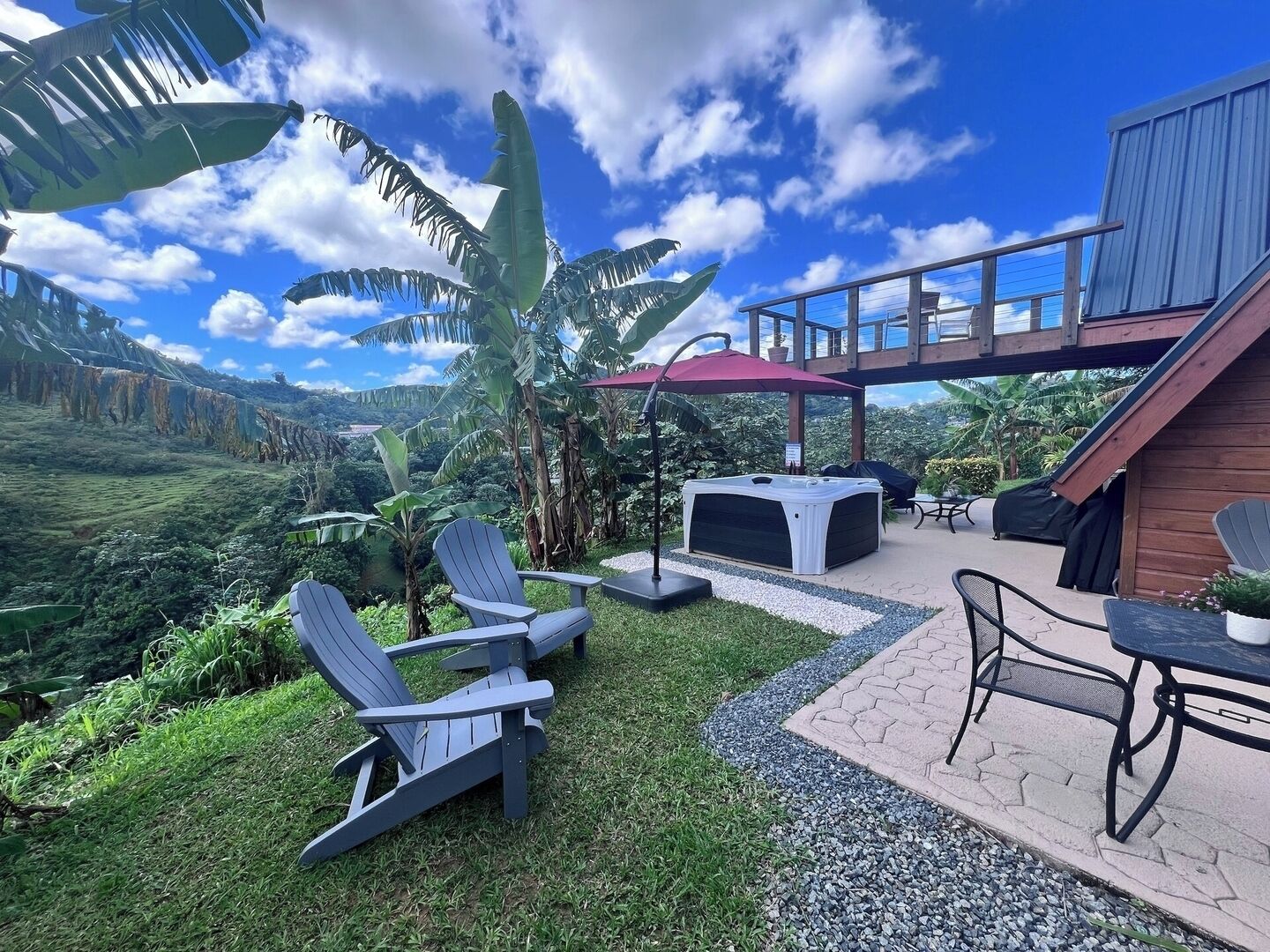 A patio area with Adirondack chairs, a hot tub, and a table with chairs.