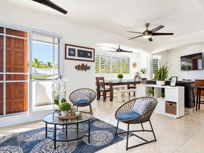 A spacious living area with a dining table, chairs, and a TV. - CasaPlaya Gamil Rene (Barceloneta)