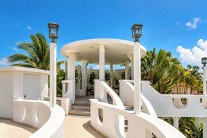 A white, modern building with a covered walkway and palm trees.