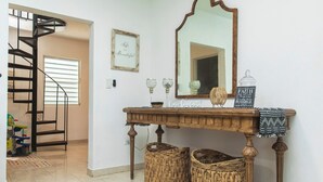 A staircase leading to a landing with a console table, wicker baskets, and decorative items.