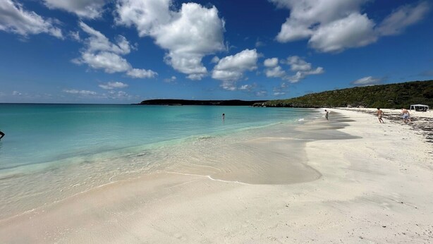 A beach with clear turquoise water, white sand, and a distant hill. - Paradise Beach Apartment Vieques 6 (Vieques)