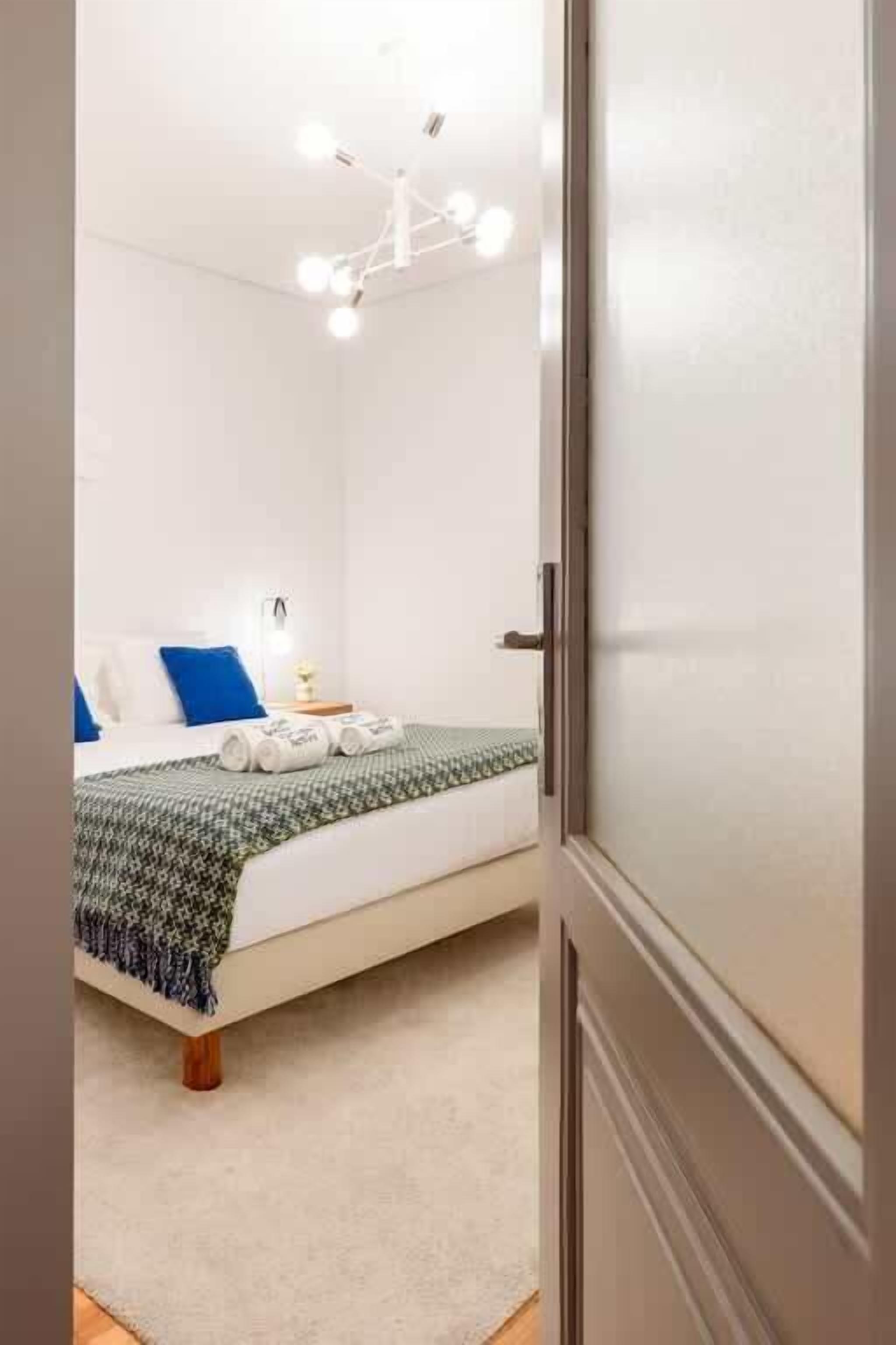Un dormitorio con cama, mesita de noche, lámpara y lámpara colgante.