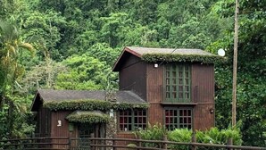 A rustic wooden house with a thatched roof, surrounded by lush greenery. - Paradise Ciales W/ Private Climatized Pool (Ciales)