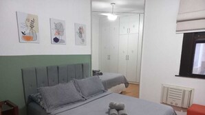 A bedroom with a bed, a wardrobe, and a radiator.