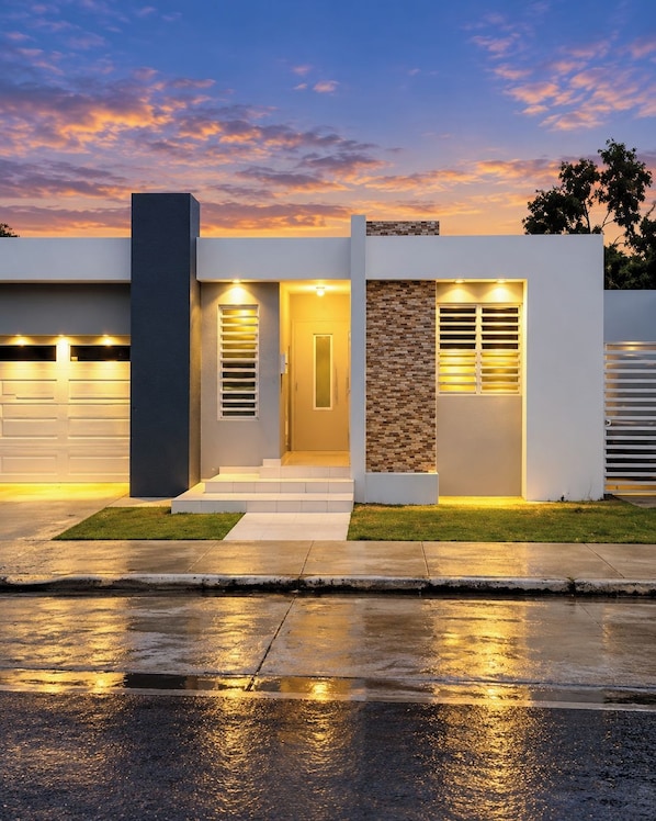 A modern two-story house with a garage, a front entrance with steps, and a driveway.